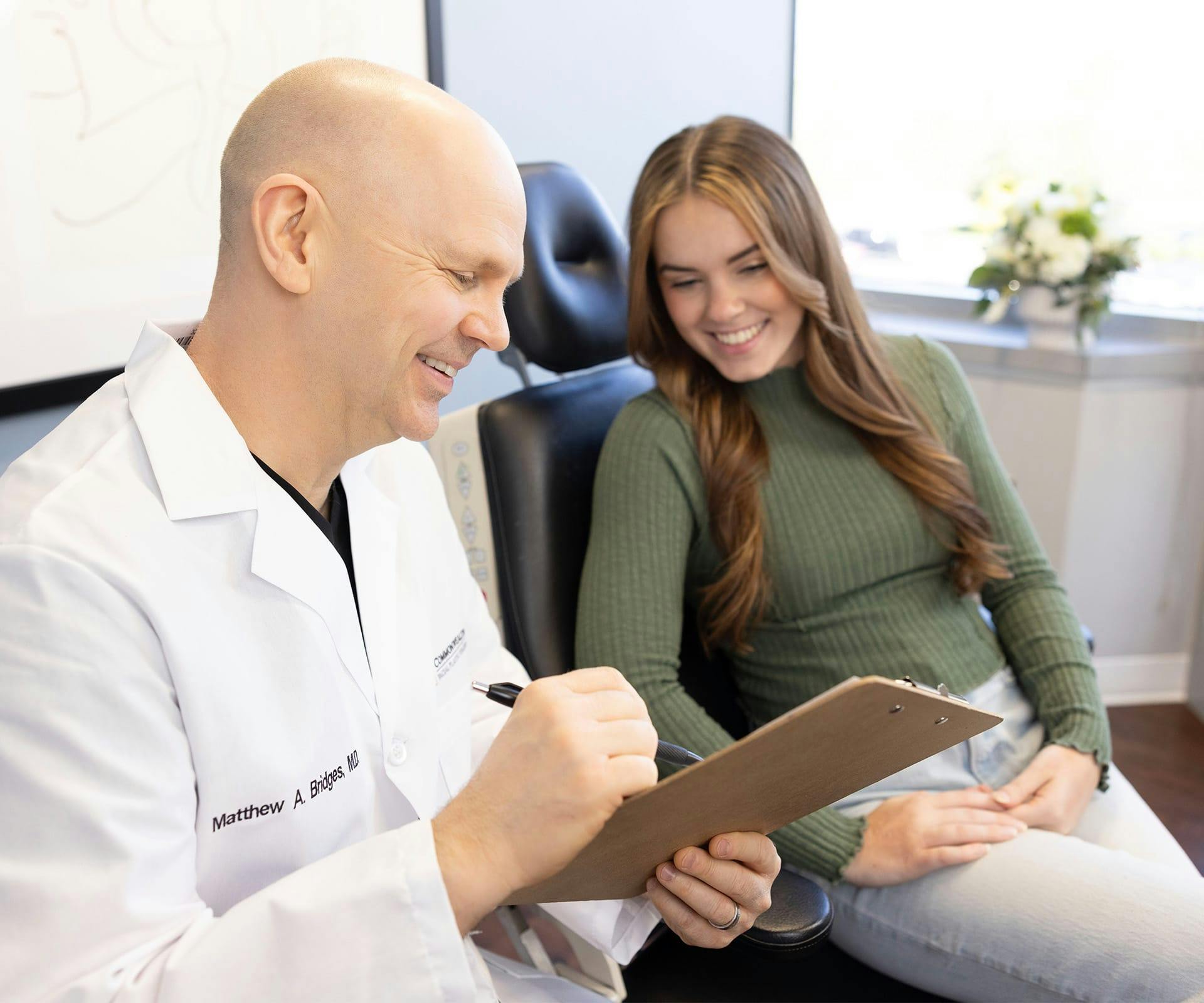 Dr. Bridges showing woman something on clipboard