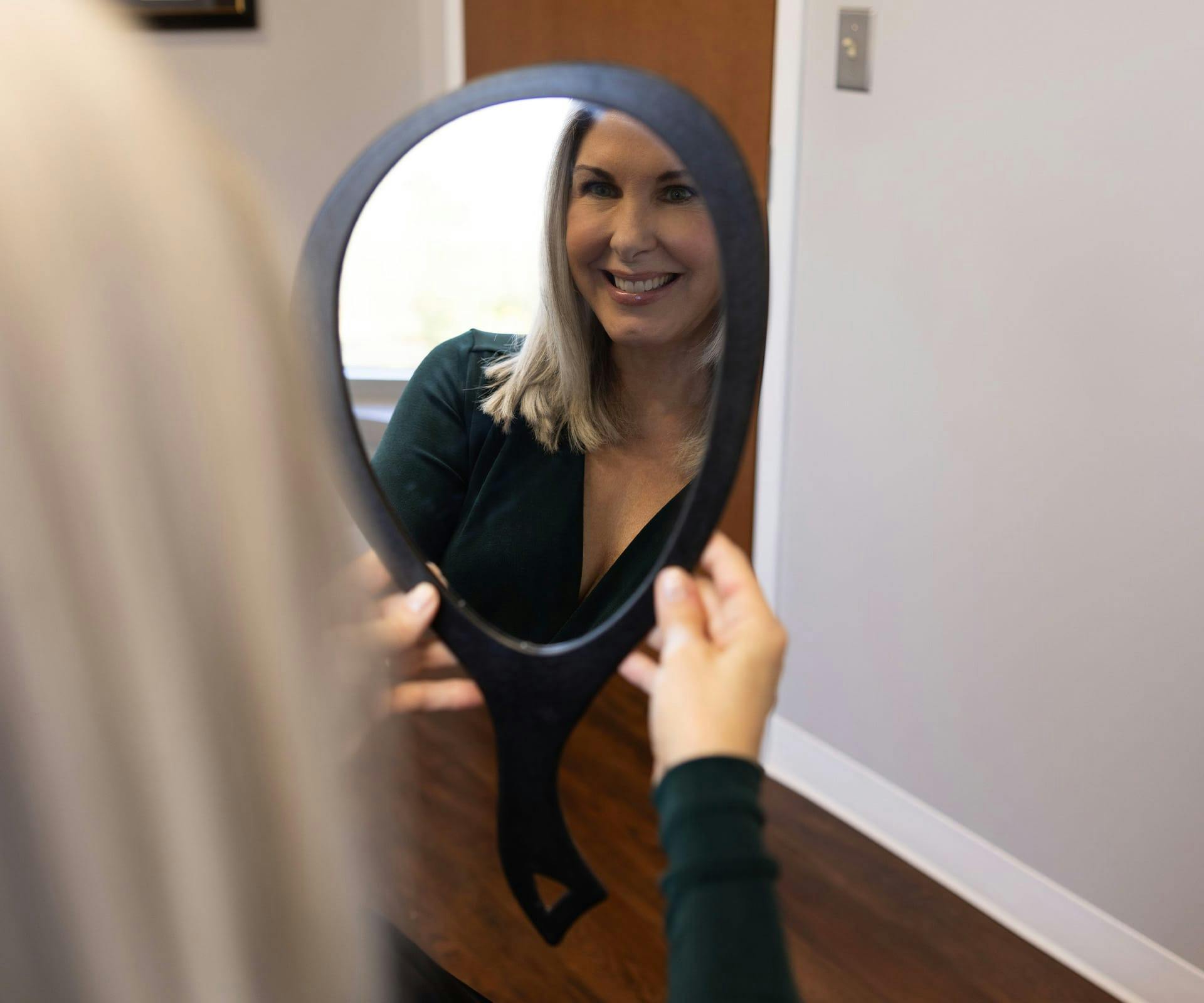 Woman smiling into mirror