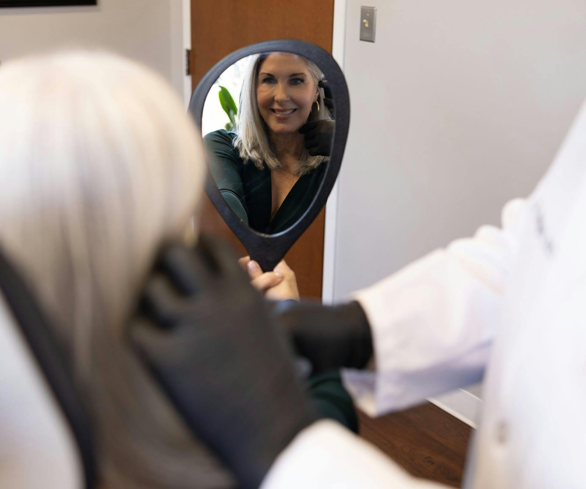 woman looking in hand mirror