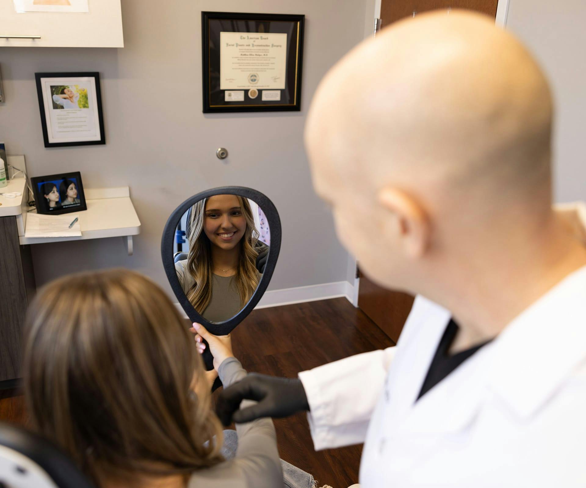 Patient looking in mirror with Dr. Bridges