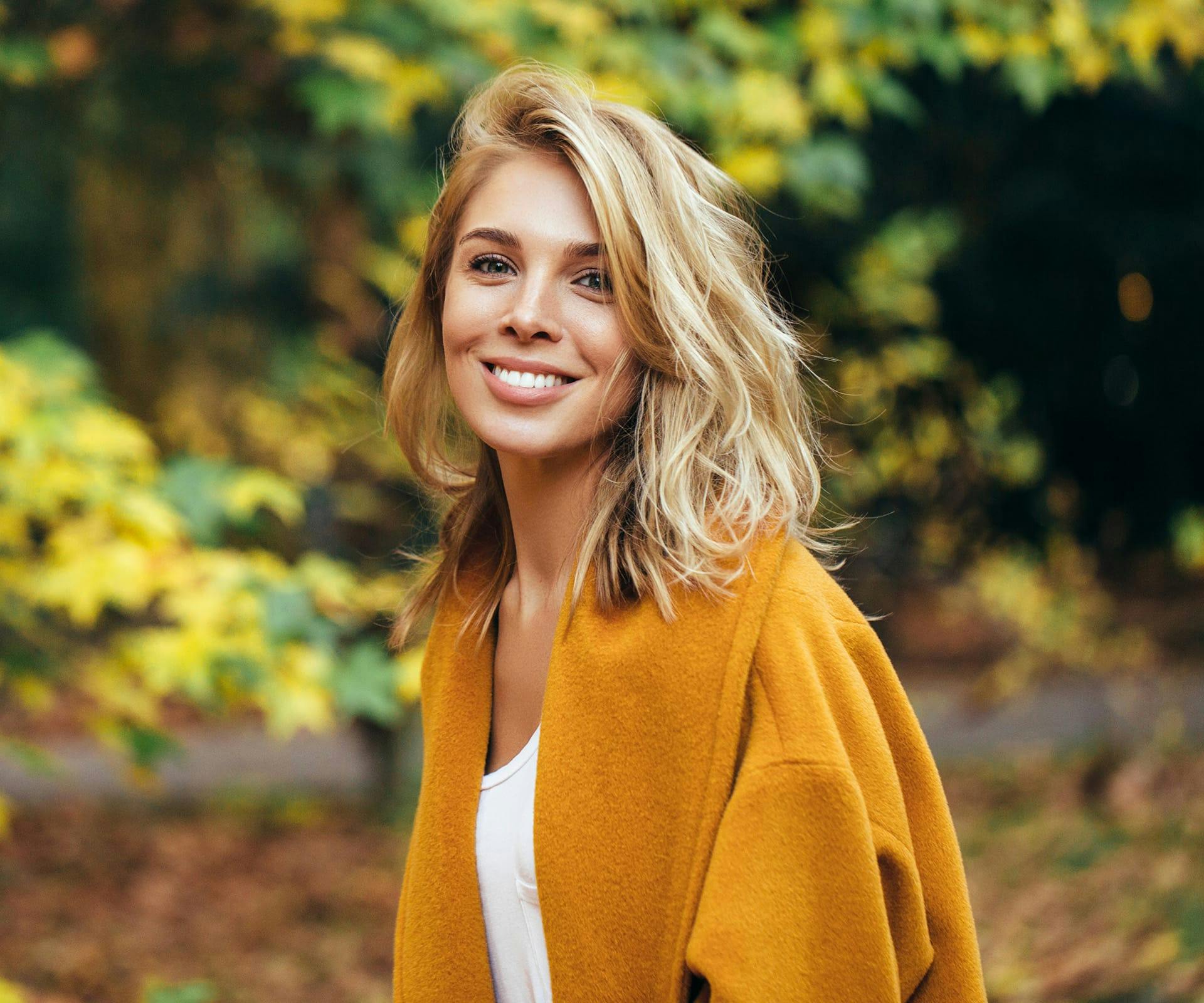 Woman in felt jacket smiling over her shoulder