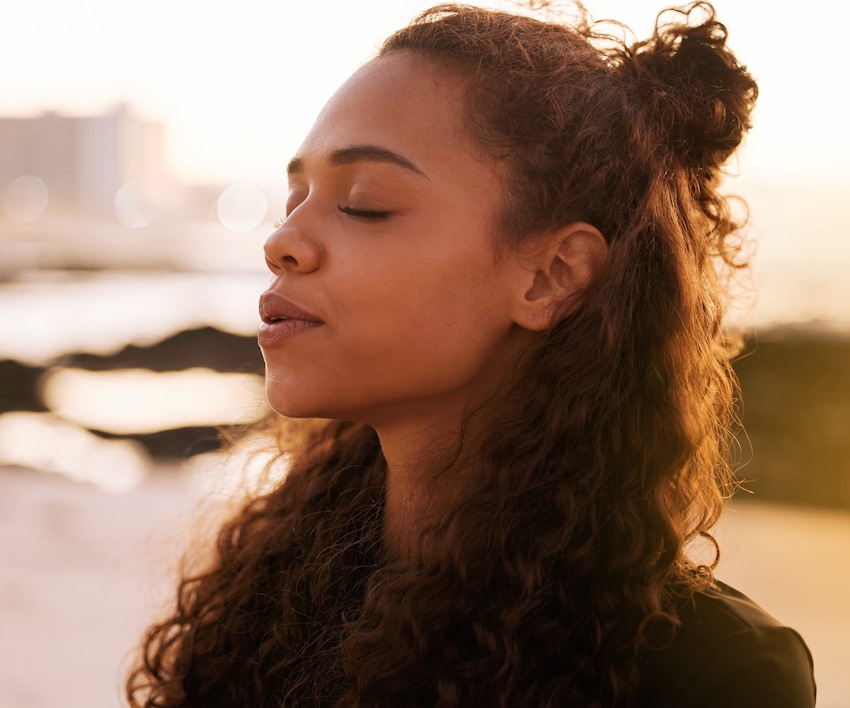 woman outside with her eyes closed