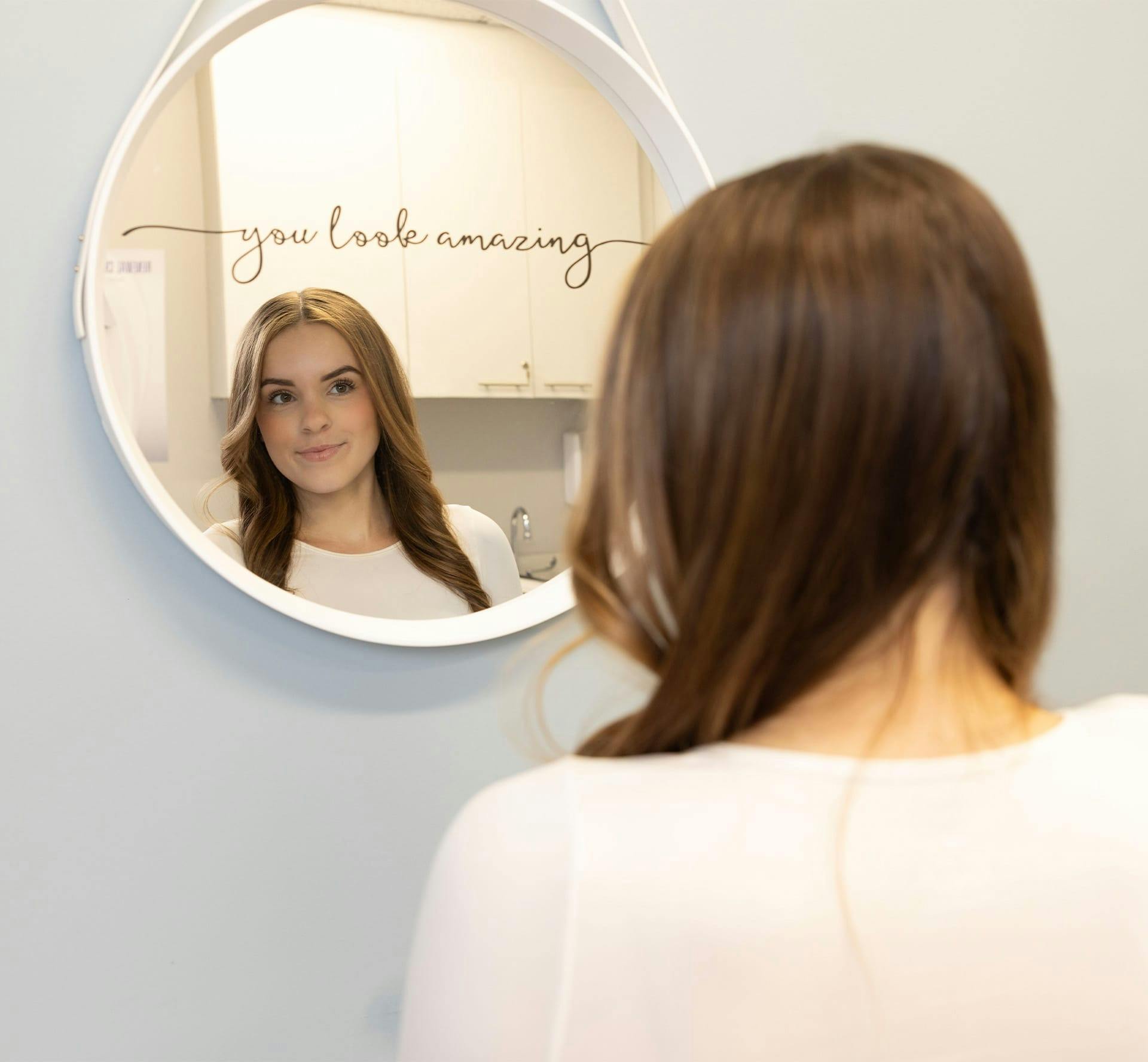 Woman smiling into mirror