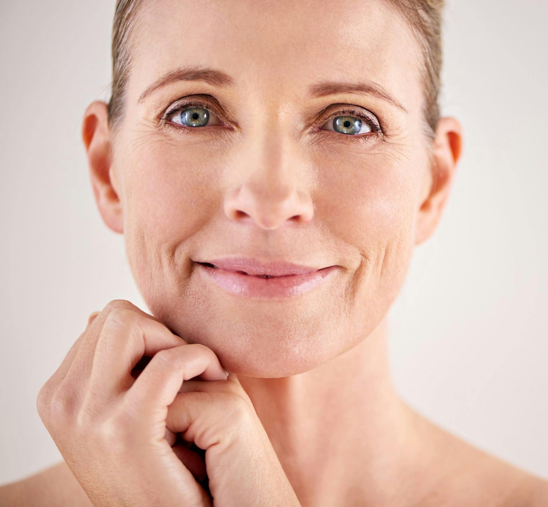 Woman smiling with hands under chin