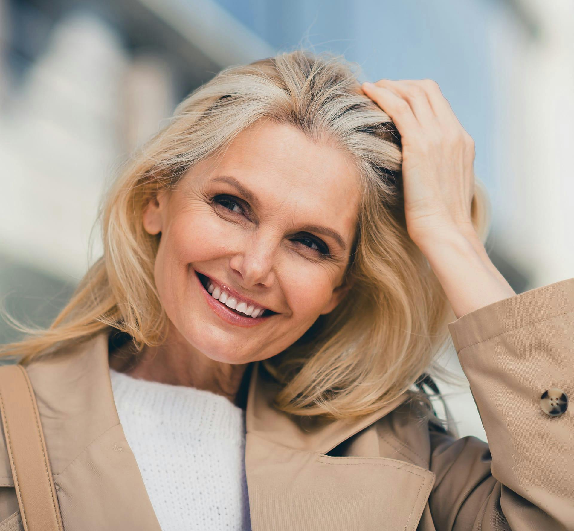 Woman smiling while running hand through hair