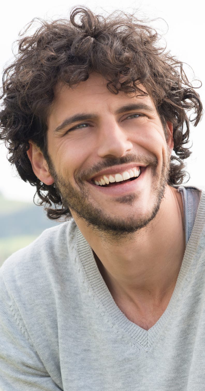 Man with curly hair, smiling