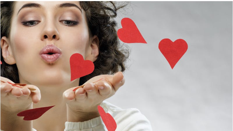 A woman blowing hearts out of her hands