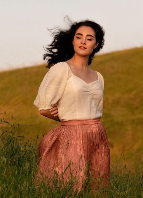 woman in a field with the wind blowing her hair