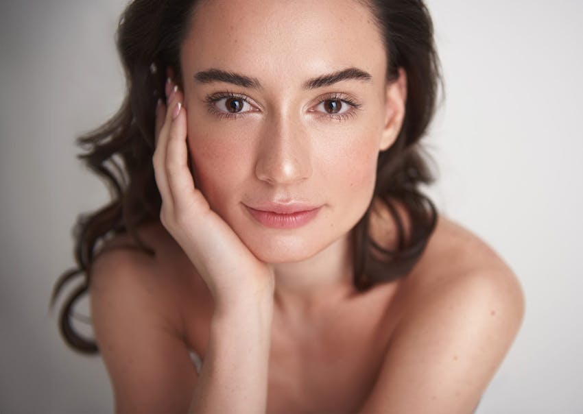 Woman smiling while resting head in hand