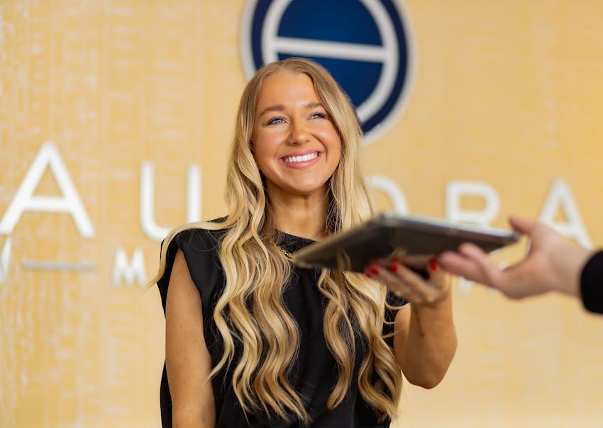 Aurora practitioner handing someone an iPad