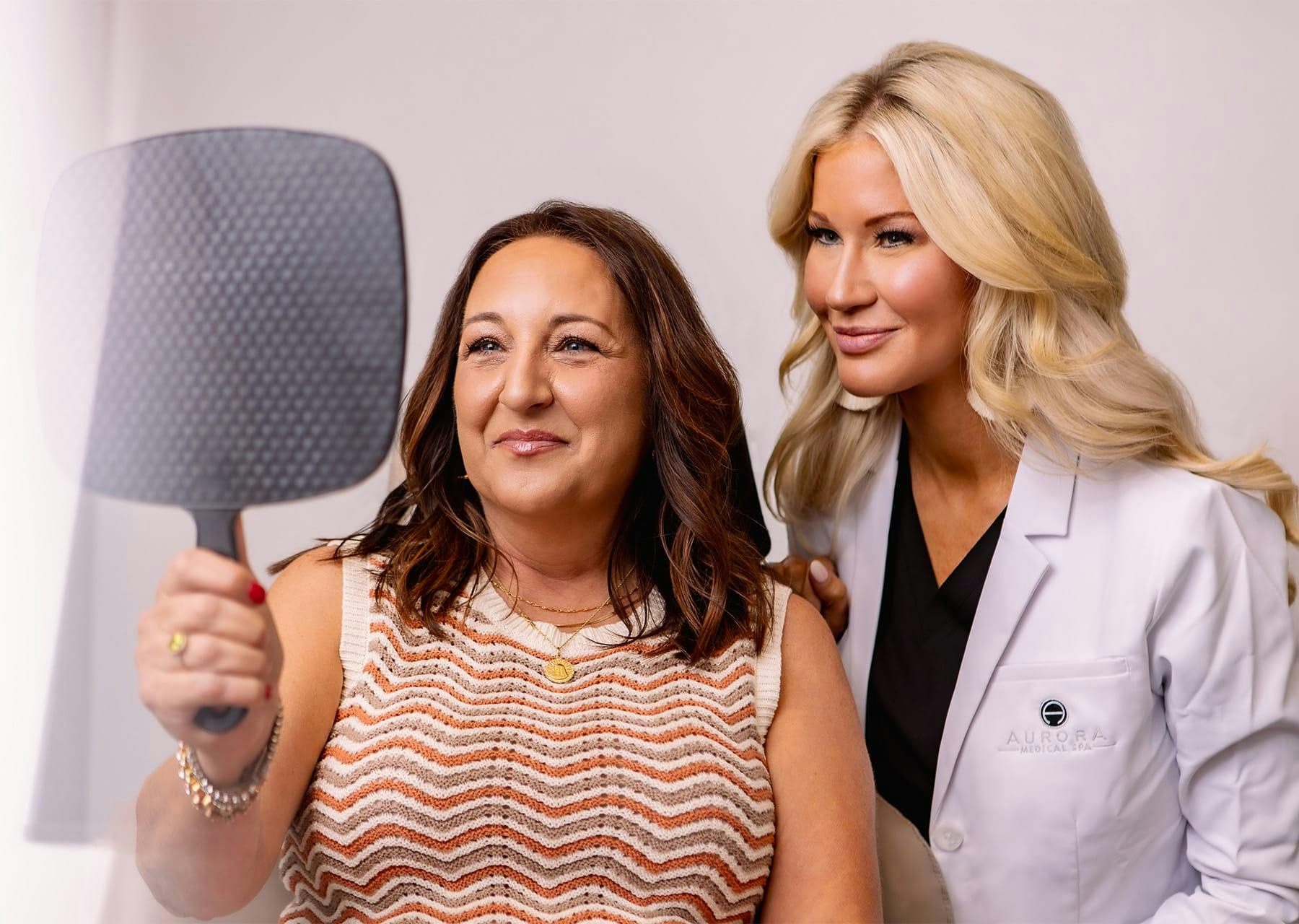woman looking at her face treatment results in a mirror