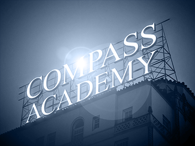 Compass logo på toppen af en bygning, hvor der er en Adobe Photoshop Lens Flare effekt bag logoet.