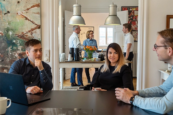 to mænd og en kvinde sidder og snakker afslappet, mens de er igang med kursus hos Compass