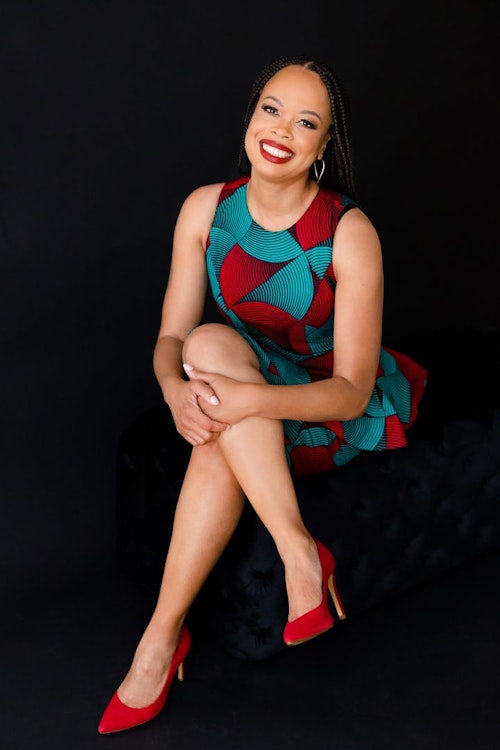 Sharitta sitting smiling with legs crossed