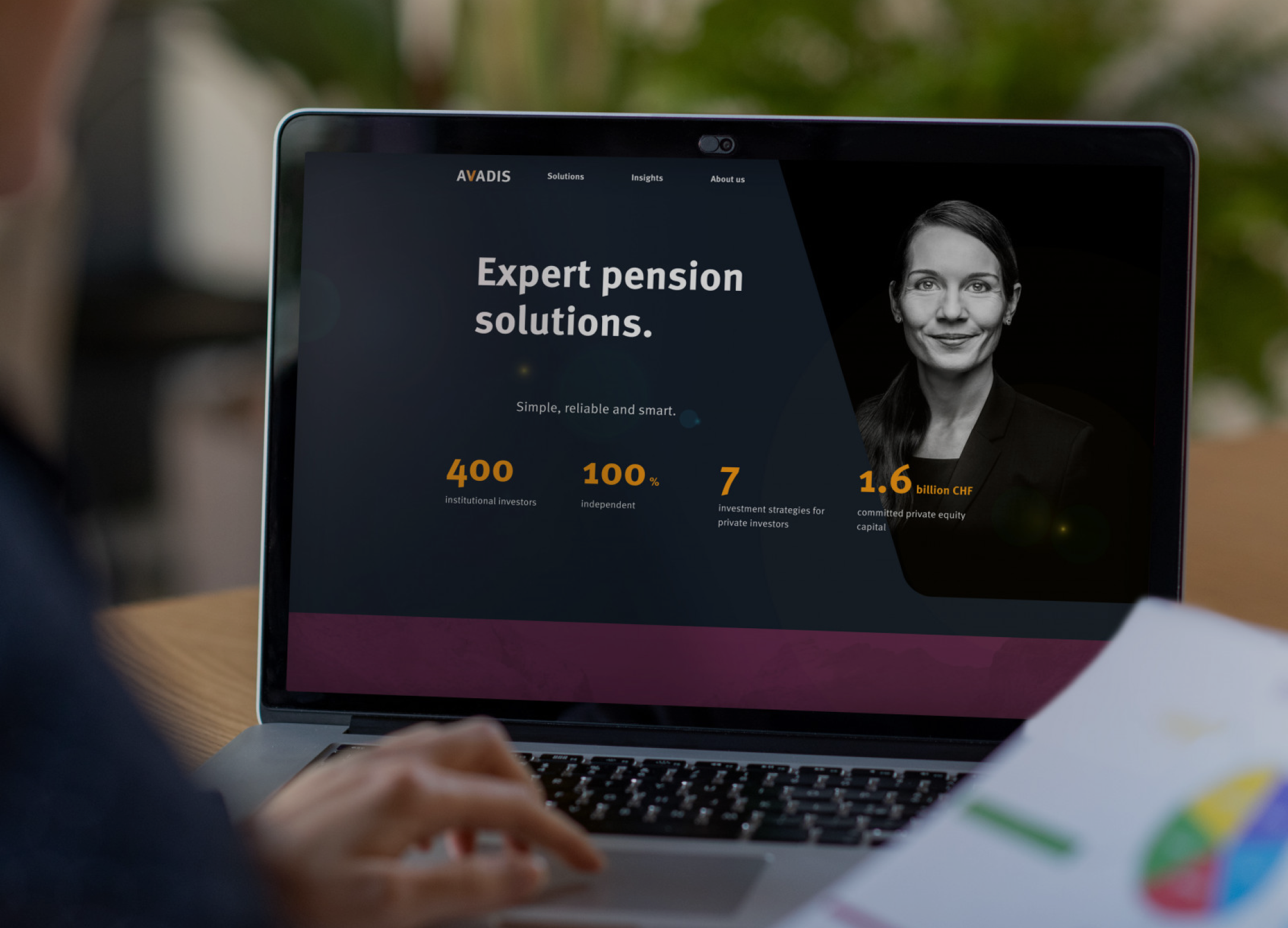 Person viewing a website on a laptop. The screen shows "Expert pension solutions" with statistics and an image of a woman.
