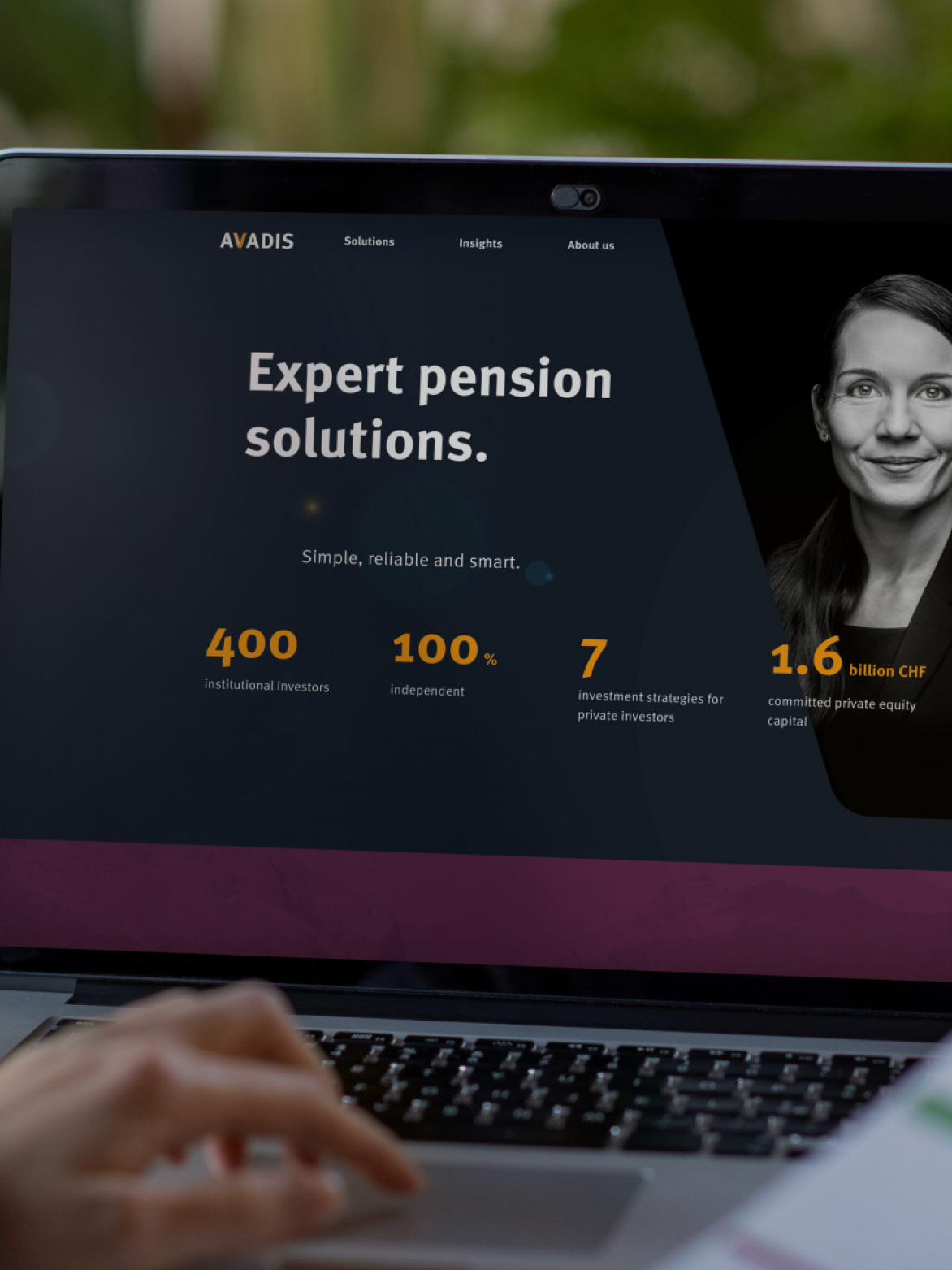 Person viewing a website on a laptop. The screen shows "Expert pension solutions" with statistics and an image of a woman.