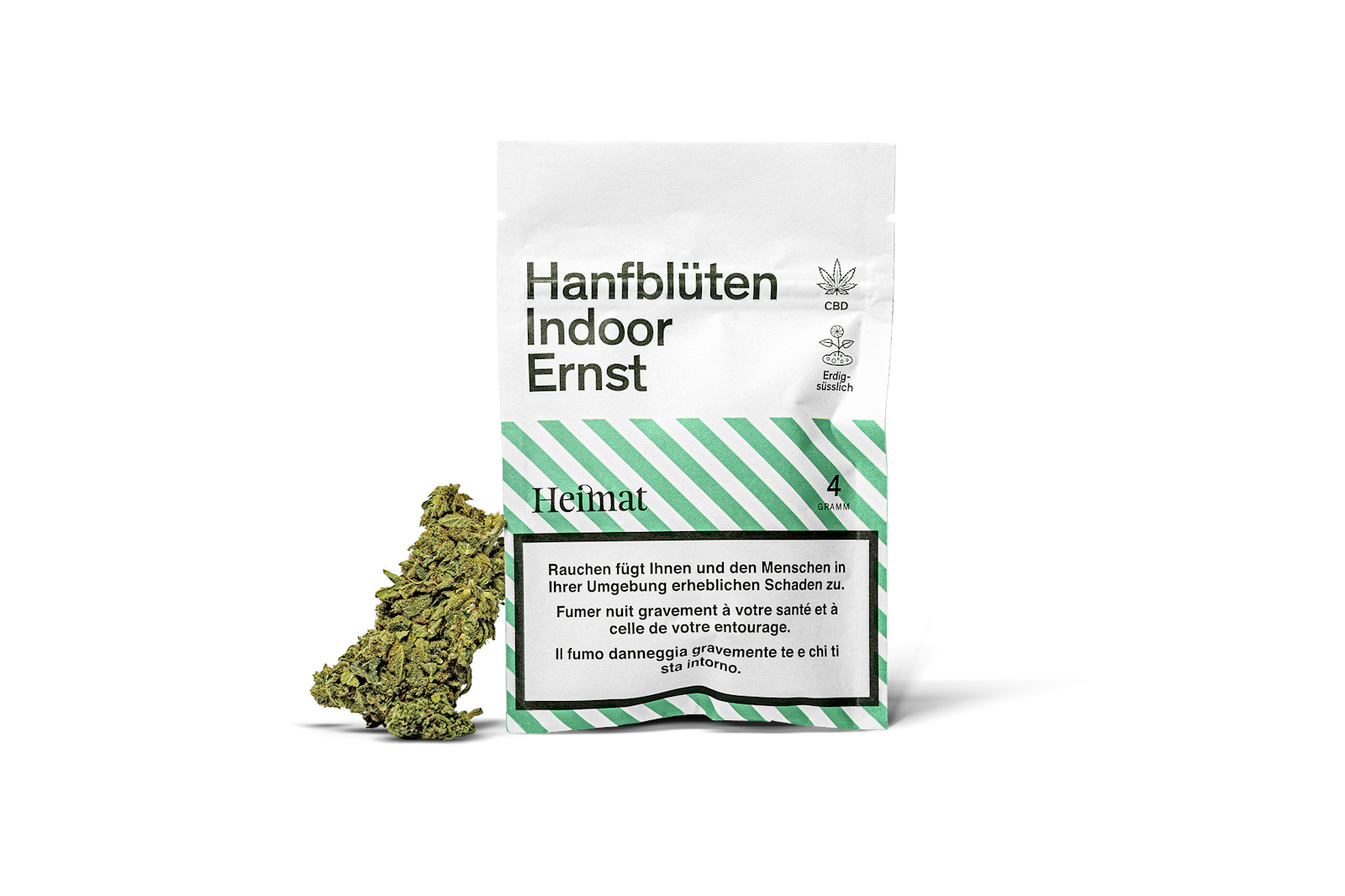 A packet labeled "Hanfblüten Indoor Ernst" with a green and white design, alongside a small amount of dried cannabis.