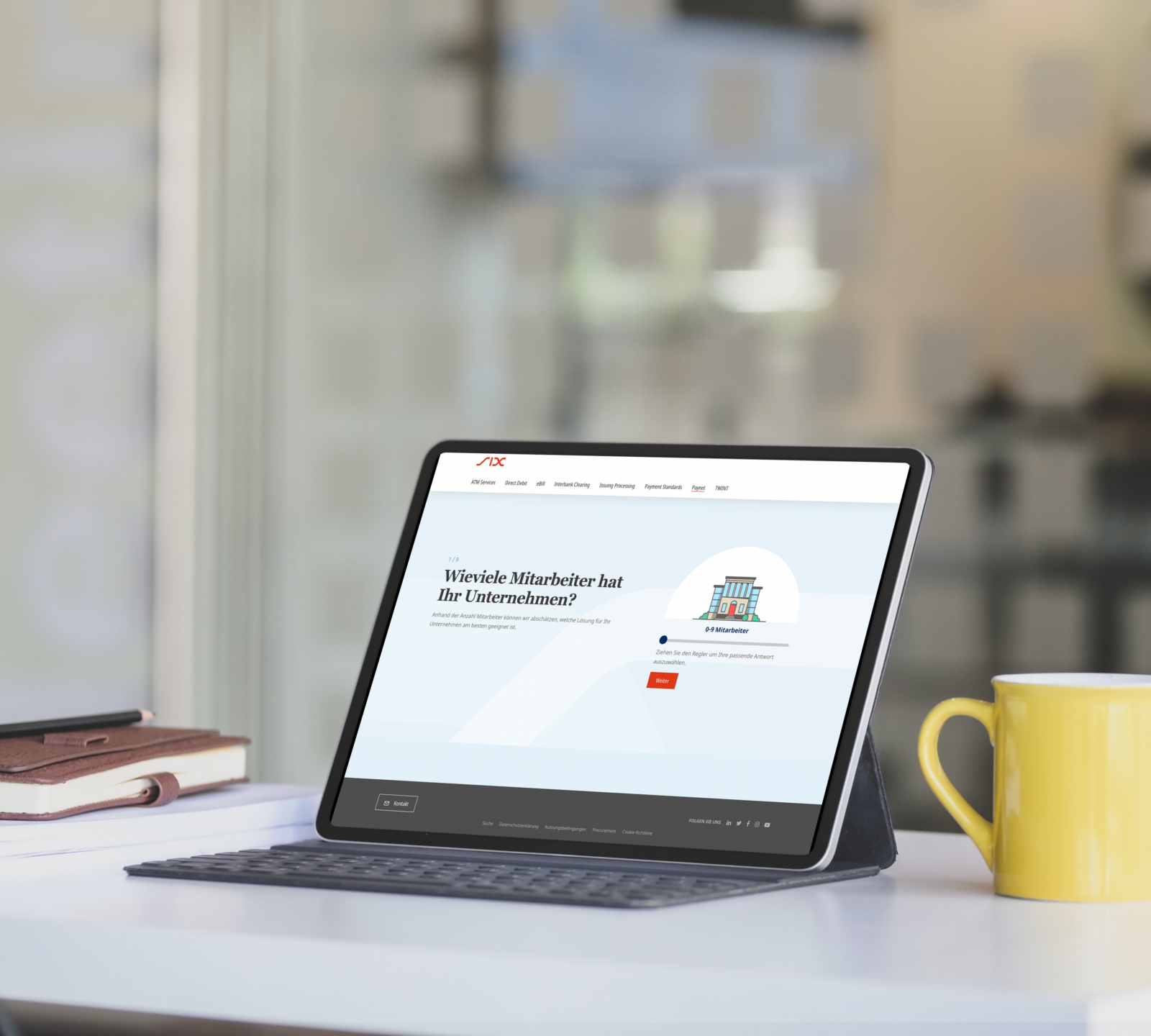 Tablet on a table displaying a website with a question about company employees. A keyboard case, a stack of books, and a yellow mug are also on the table.