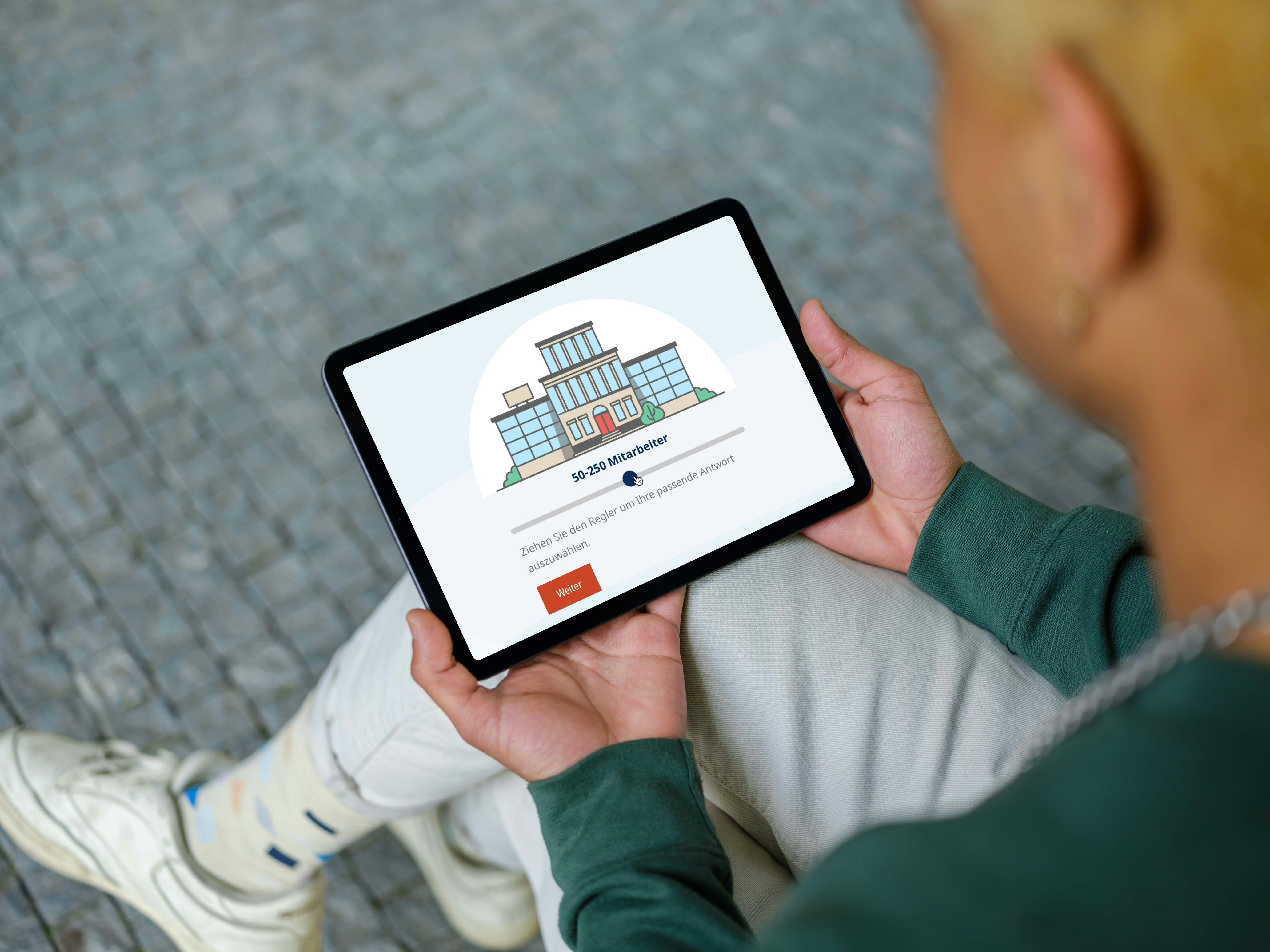 A person holds a tablet displaying a digital illustration of a building, with text prompting a question and a red "Start" button below.
