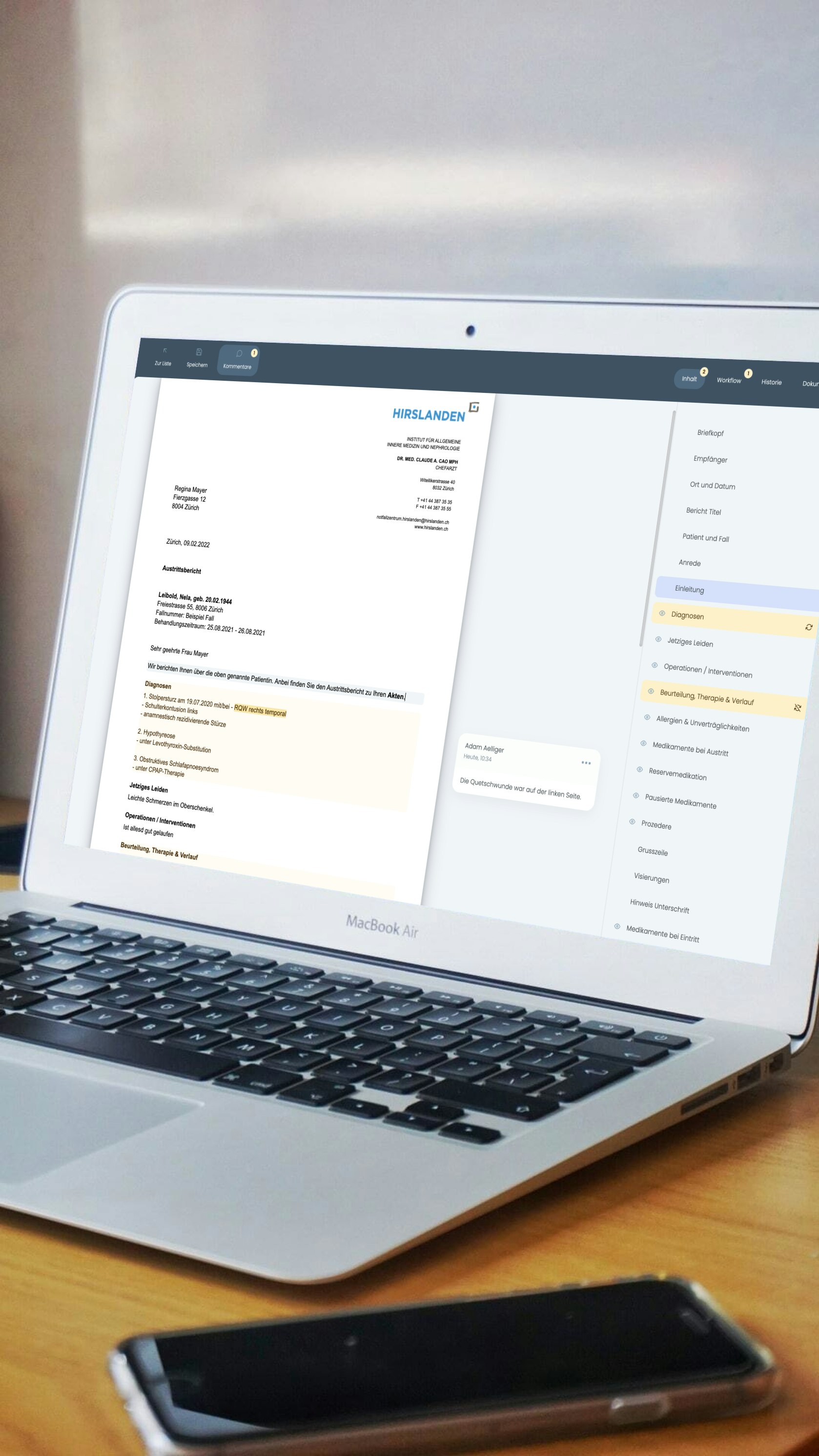 Open laptop on a desk displaying a document and sidebar. A smartphone lies in front of the laptop.