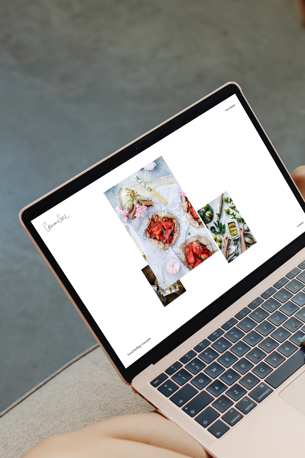 A laptop screen displays a website with images of food, including a fruit tart, surrounded by ingredients and kitchen items.