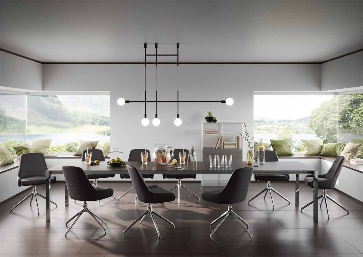 Modernes Esszimmer mit großen Fenstern, einem langen Tisch, der von acht schwarzen Stühlen umgeben ist, einer zeitgenössischen Leuchte darüber und grünen Kissen auf den Fensterbänken mit Blick auf eine malerische Landschaft mit Wasser und Hügeln.