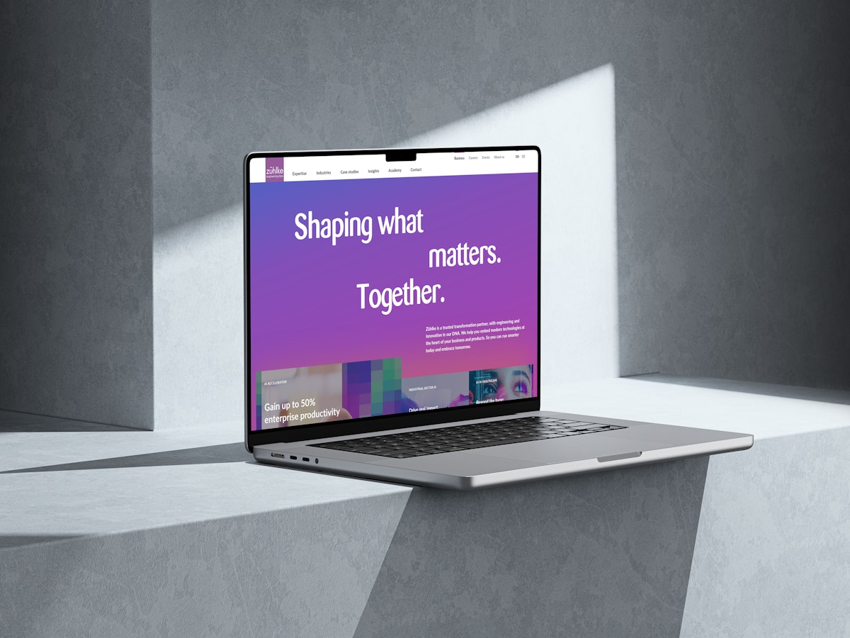 Ein Laptop steht auf einer hellgrauen Leiste, auf die das Sonnenlicht Schatten wirft. Auf dem Bildschirm erscheint eine violette Website mit dem großen Text: Gestalten, was zählt. Gemeinsam.