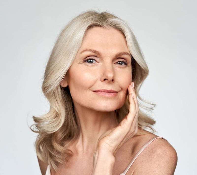 older woman touching her face