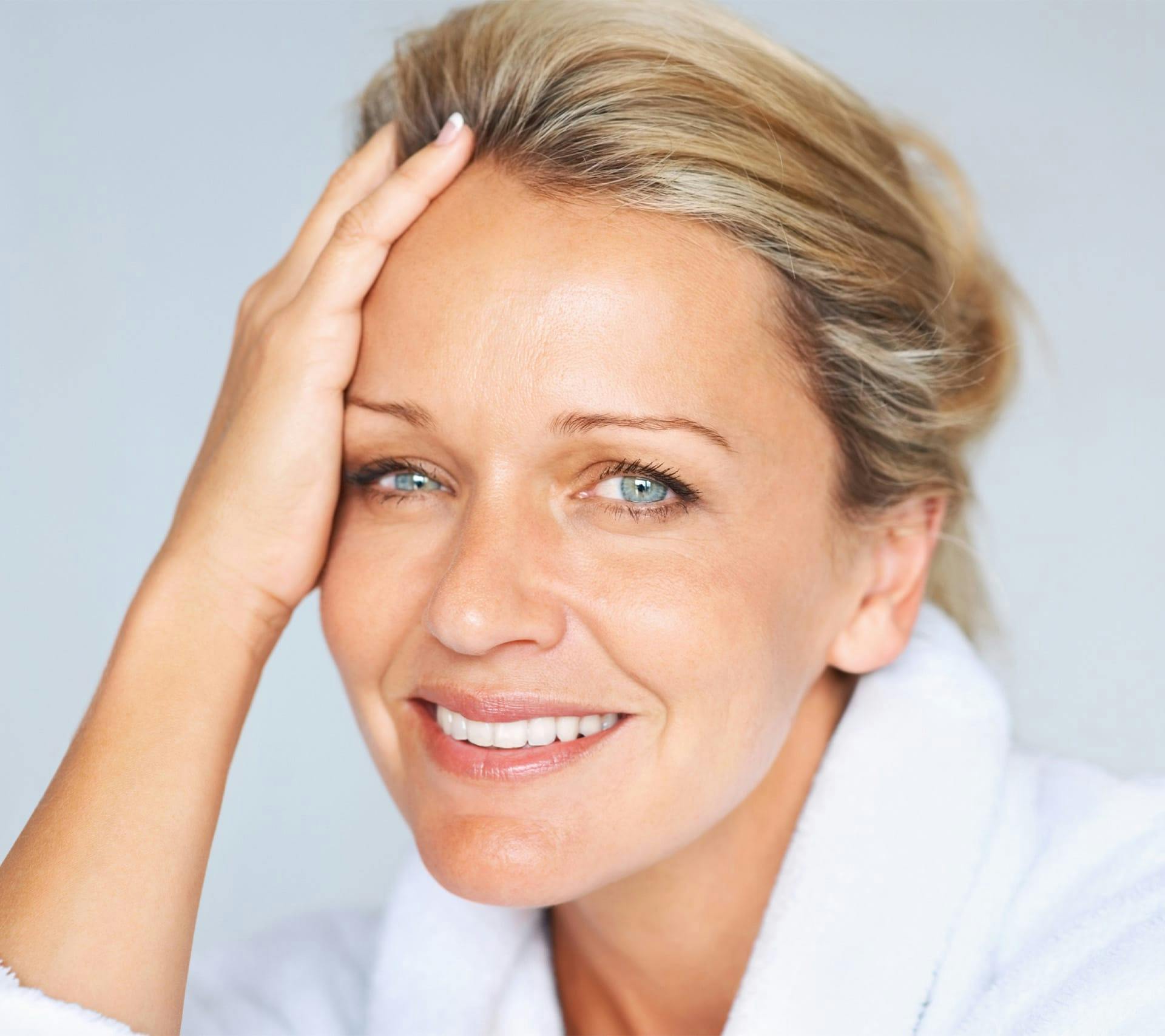 older woman touching face