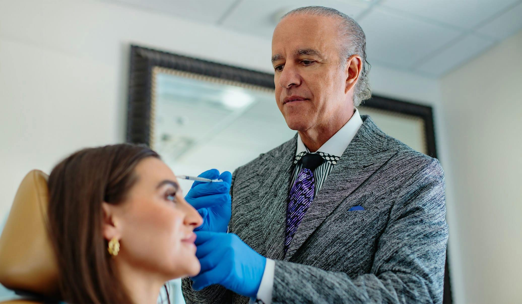 Dr. Caniglia performing botox injections on a female patient