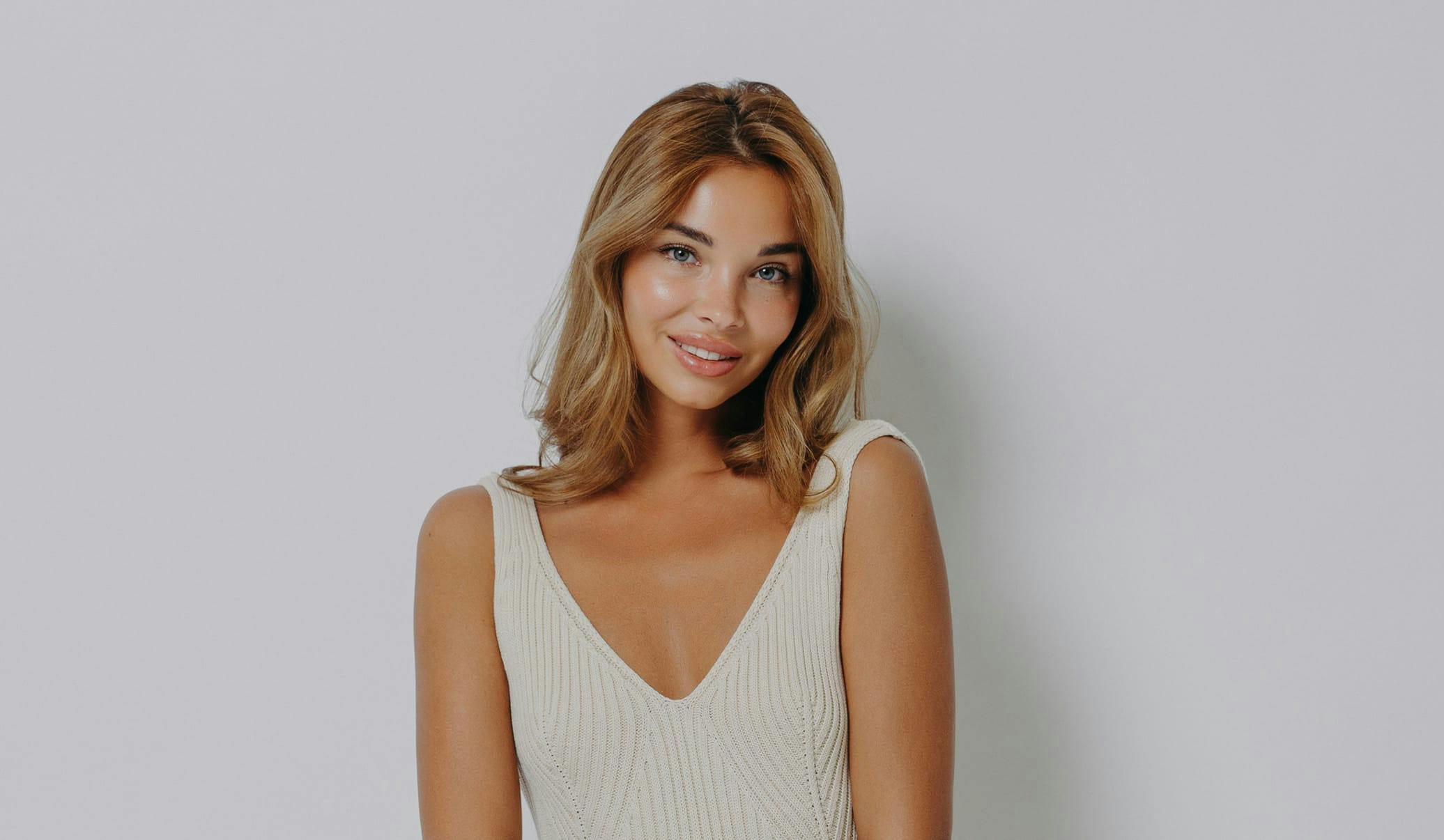 woman with blonde hair wearing a cream knit dress