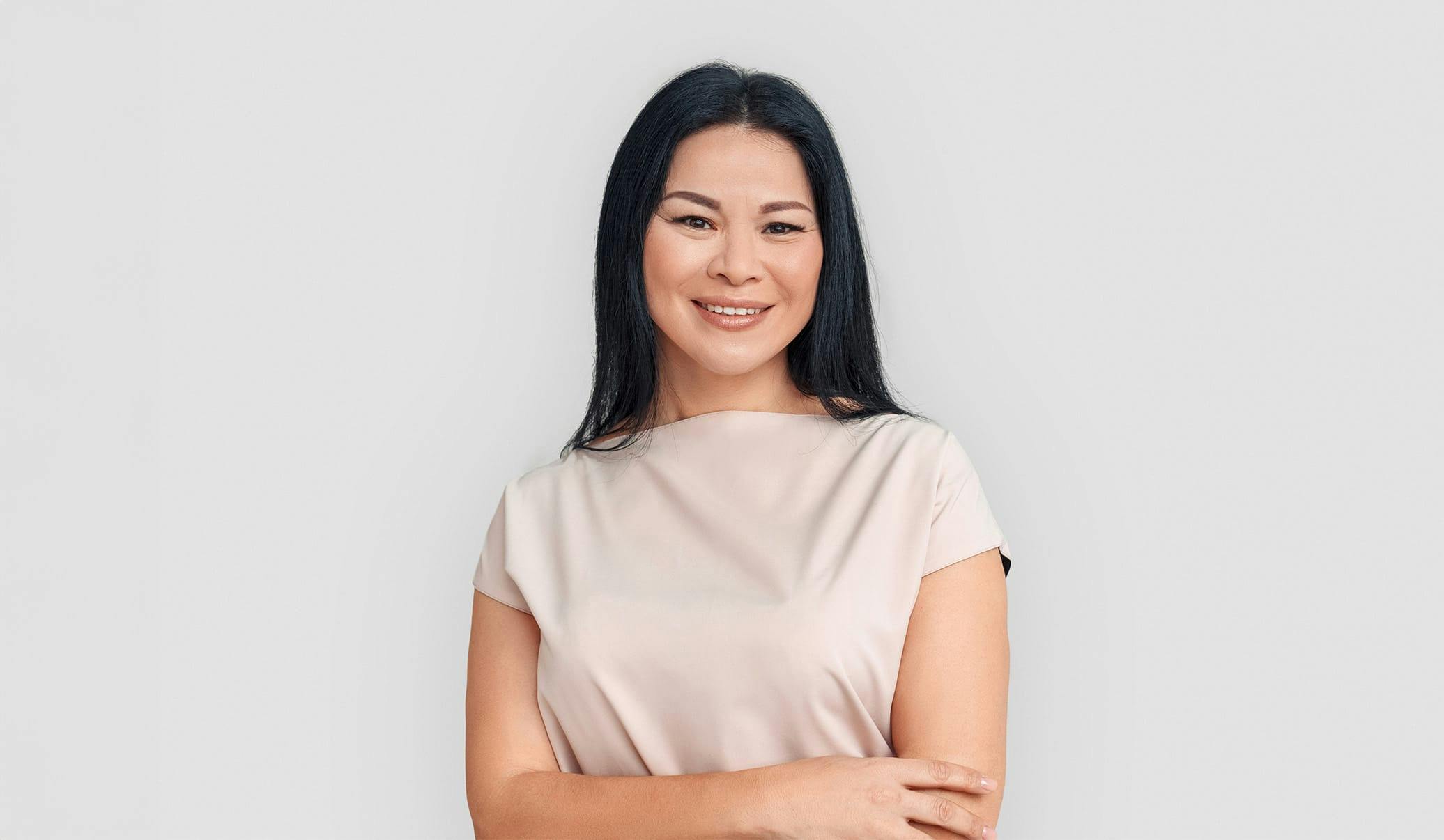 woman with long dark hair wearing a white top