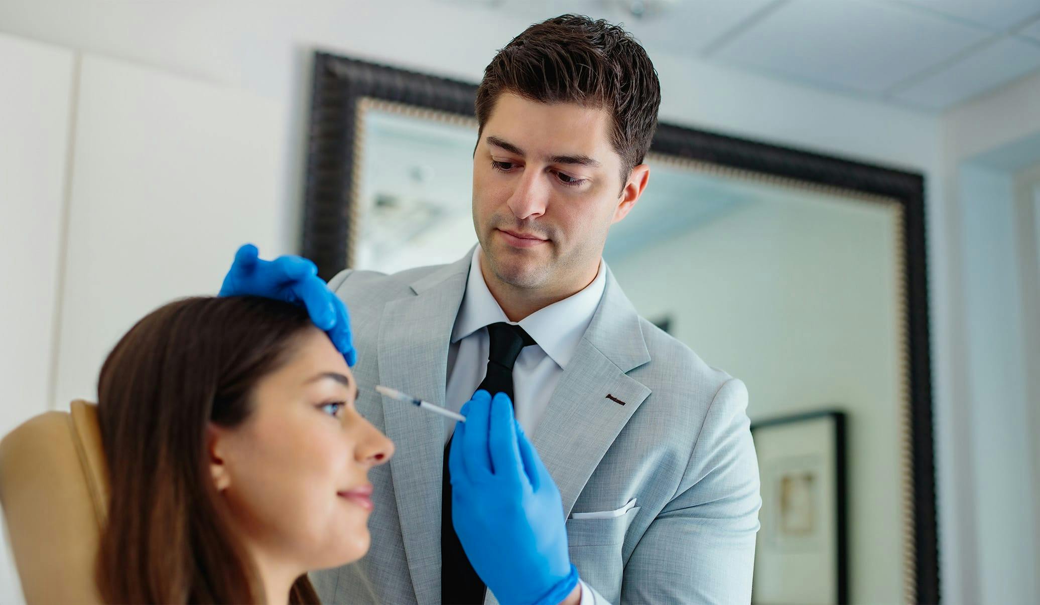Dr. Caniglia providing an injectable treatment to a female patient