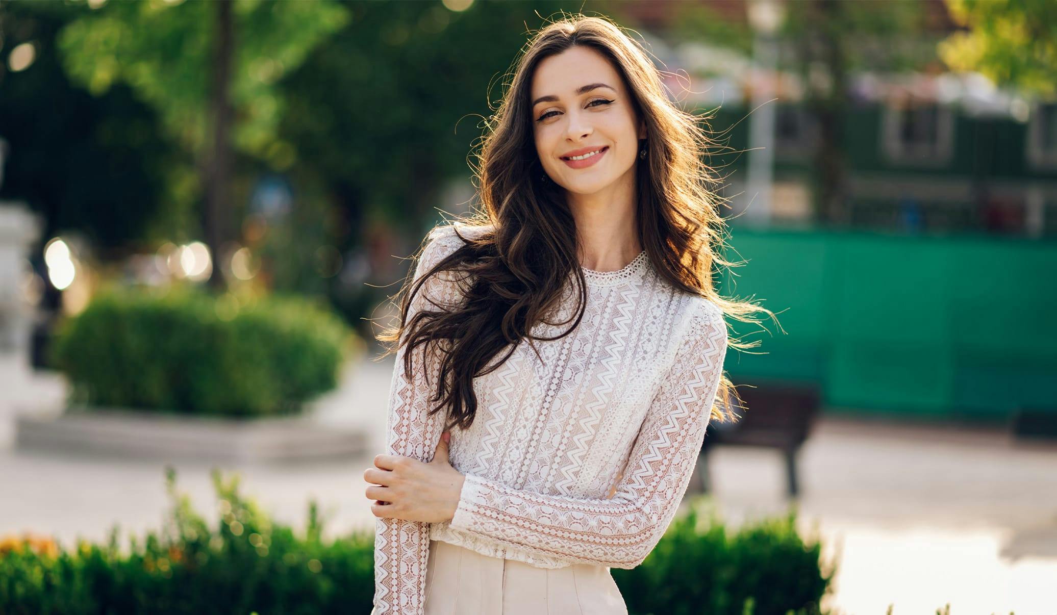 woman with long brown hair wearing a lacey top