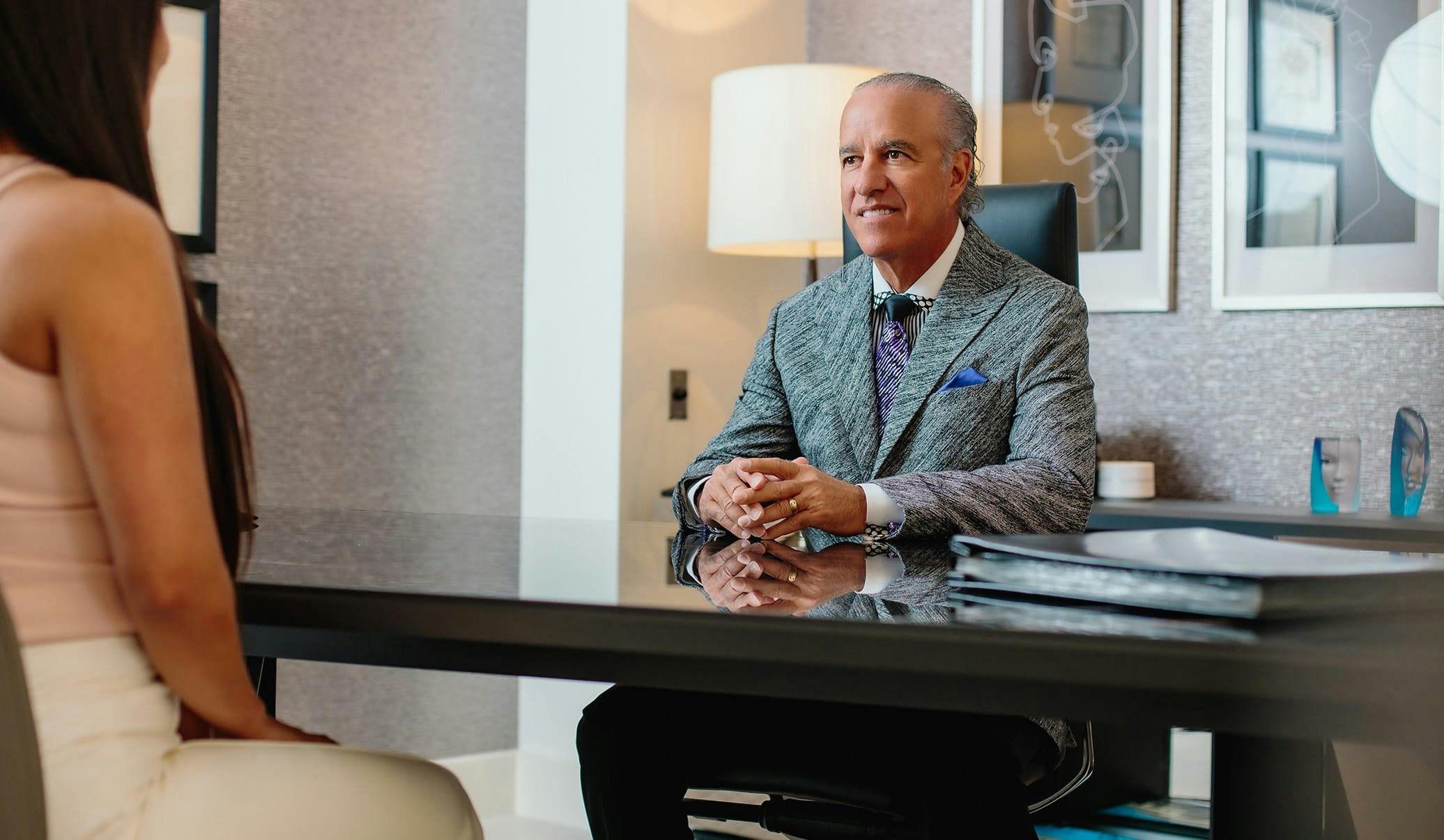 Dr. Caniglia sitting at a desk, talking to a patient