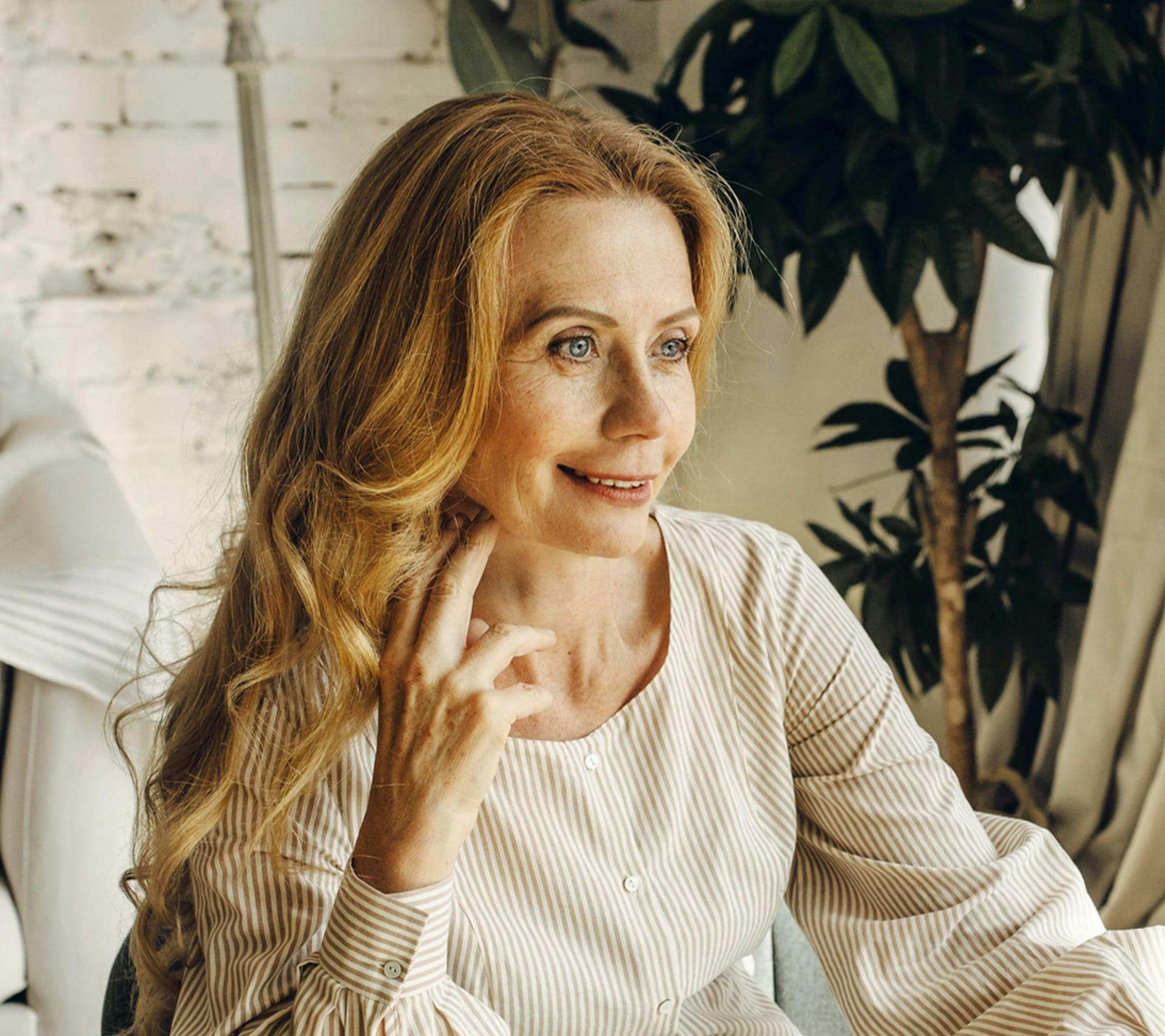 middle-aged woman with long hair wearing a long-sleeve top