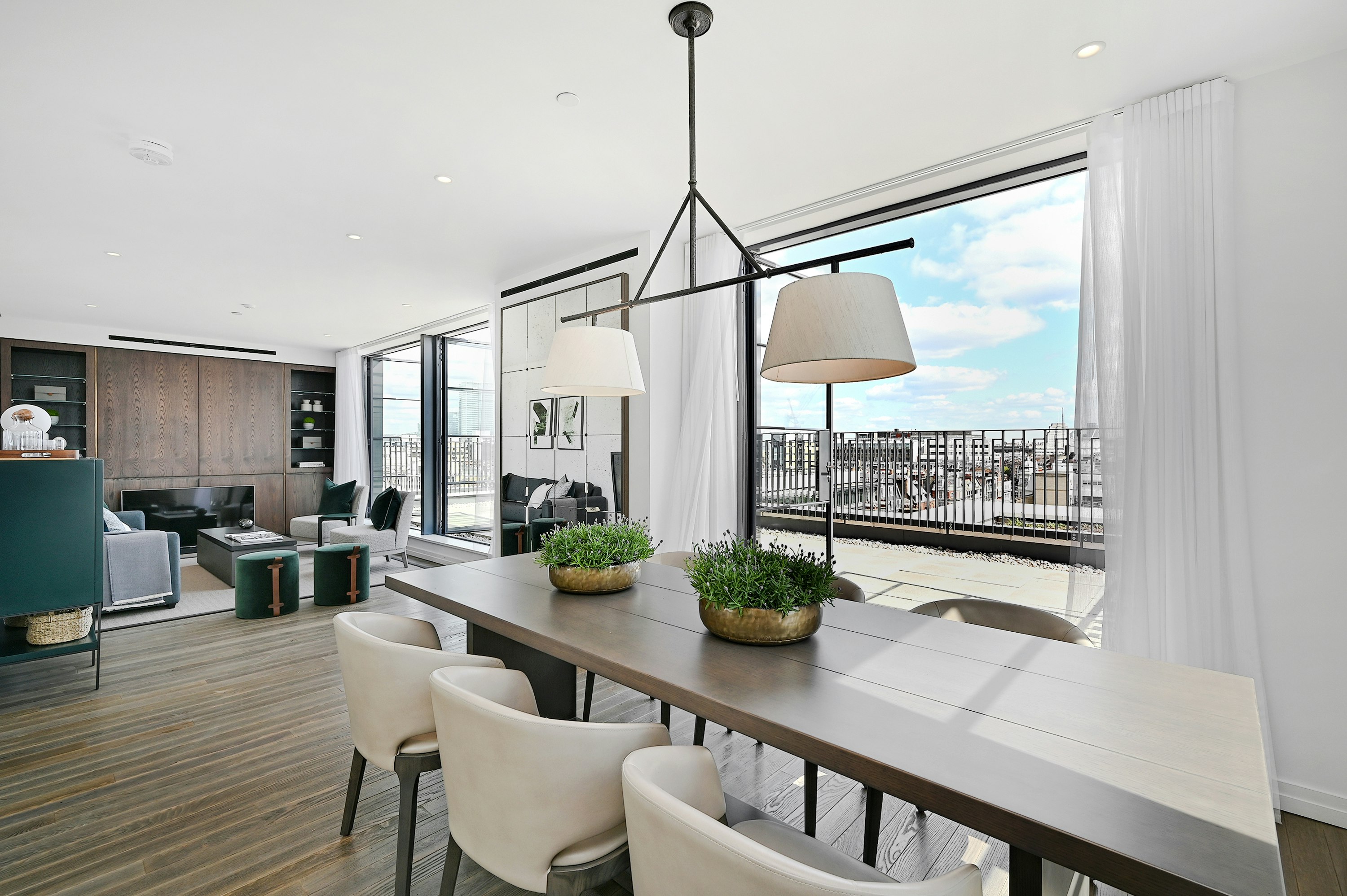 Dining table and living area looking onto to balcony