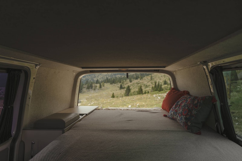 Downstairs bedroom inside a VW T5 from Balkan Campers with a pop top roof in Julian Alps, Slovenia