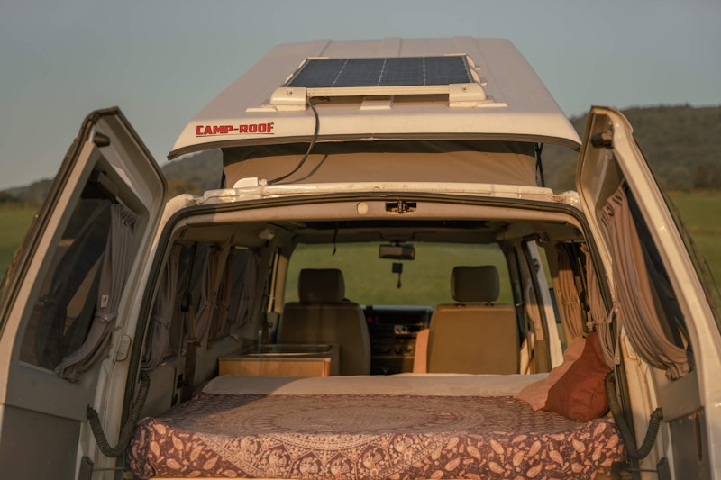 A view of VW T4 campervan with a pop top roof from the back door