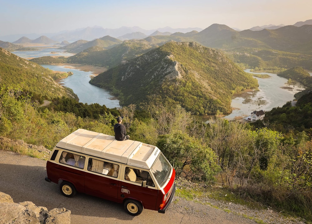 Person sitting on a roof of VW t3 from Balkan Campers in the mountains of Montenegro