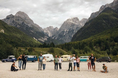 Balkan Campers crew in Julian Alps with VW campervans parked behind