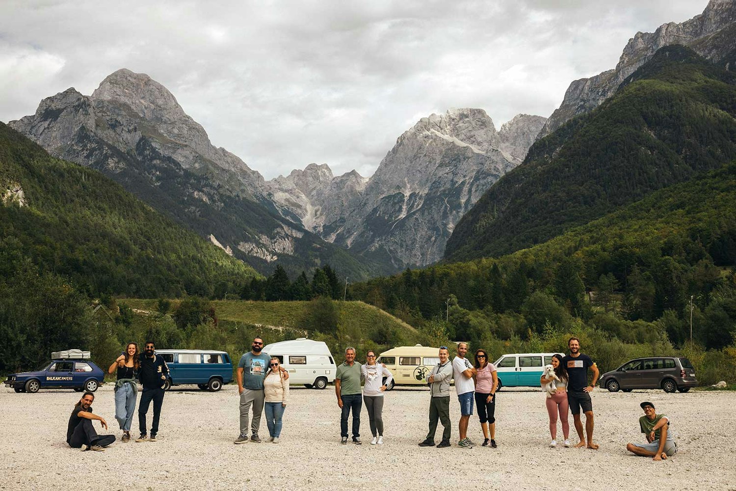Balkan Campers crew in Julian Alps with VW campervans parked behind
