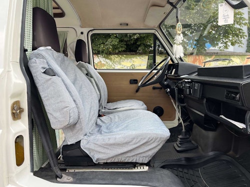 View of the front seats in VW T3 with a hard roof top and standing height from Balkan Campers