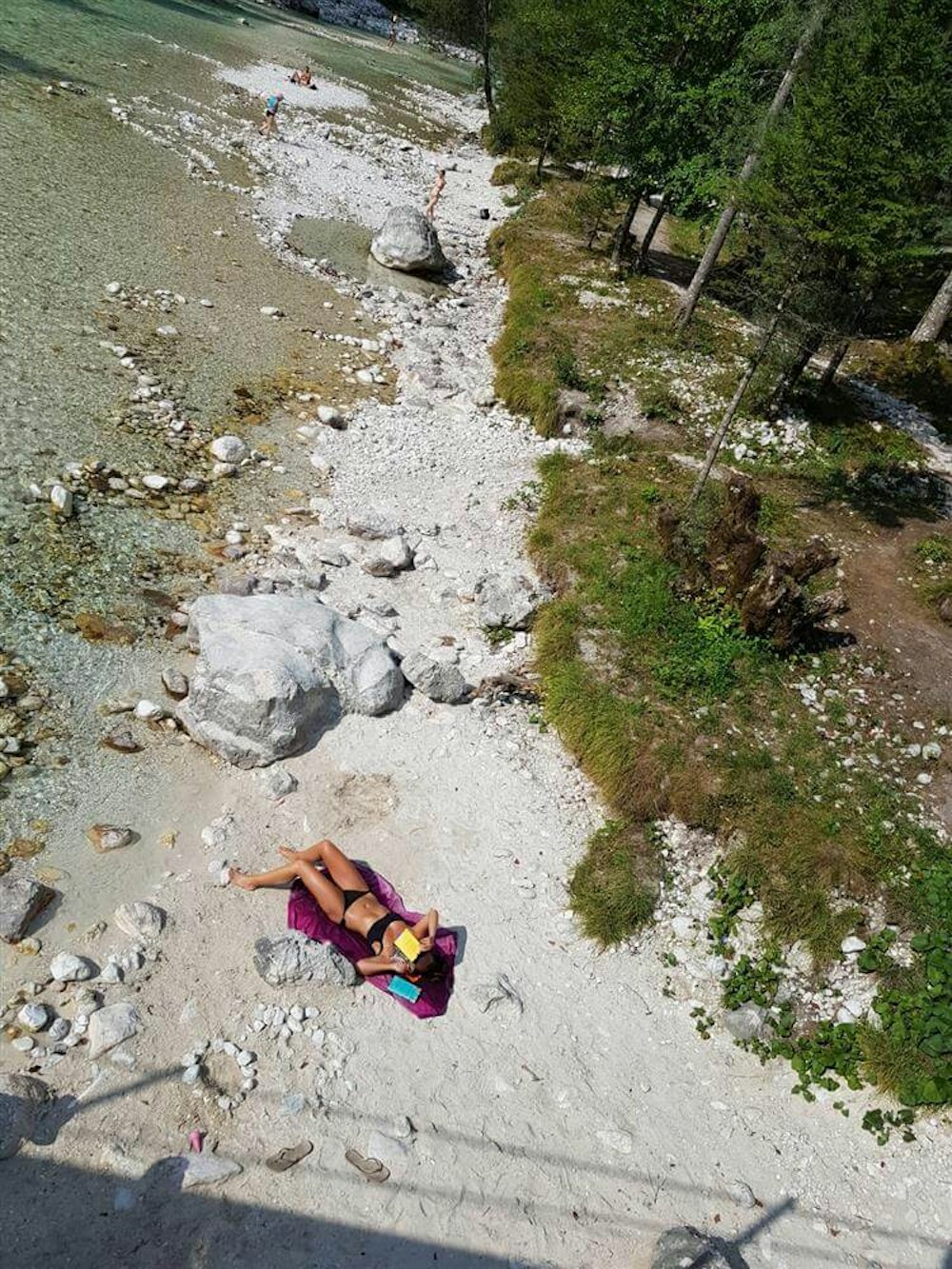 Women sunbathing at the brink of Soča river, Slovenia