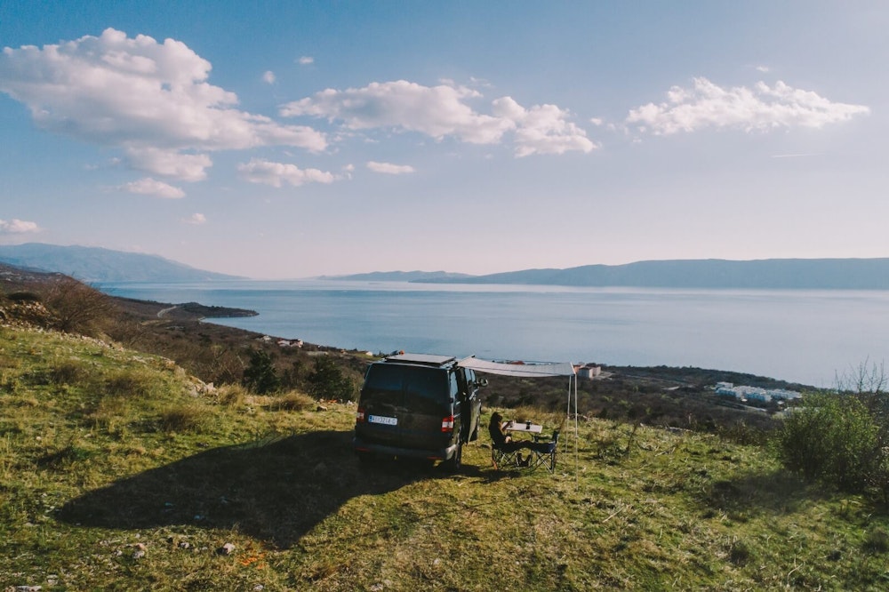 Black VW T5 campervan parked with a view of adriatic sea
