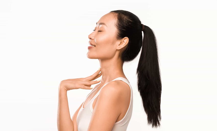 Woman smiling touching neck