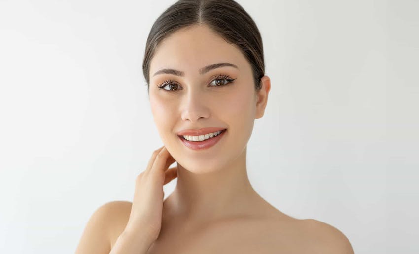 Woman smiling with hand on neck