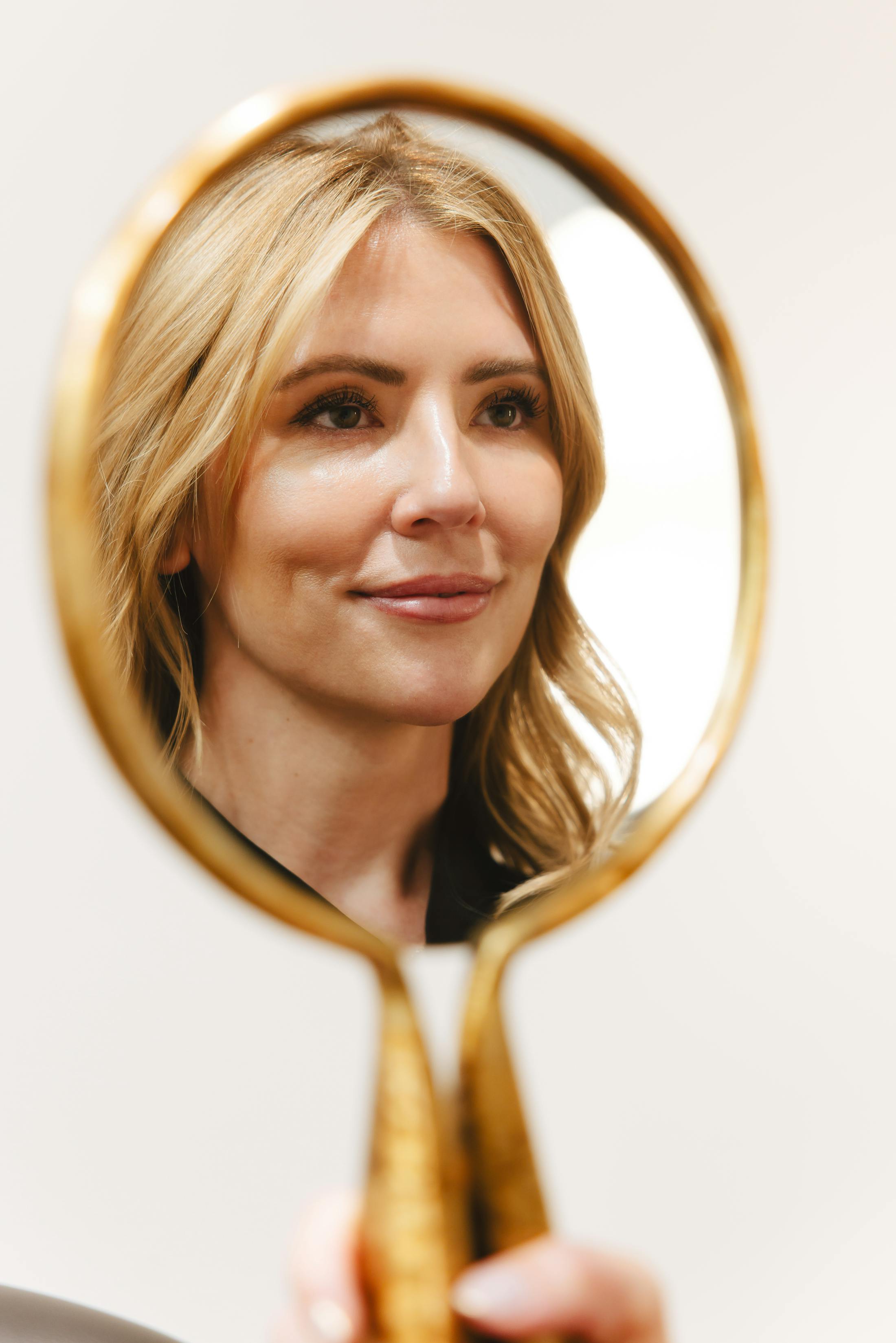 blonde woman looking into mirror
