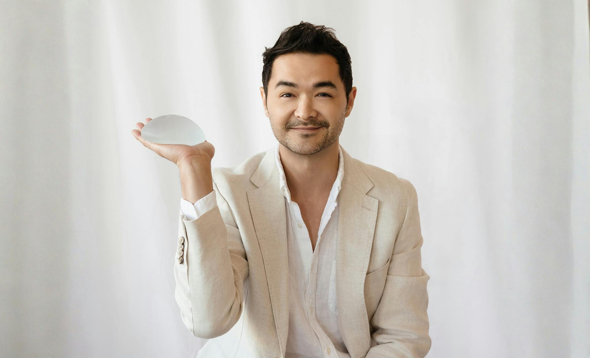 Dr. David Hill holding a breast implant