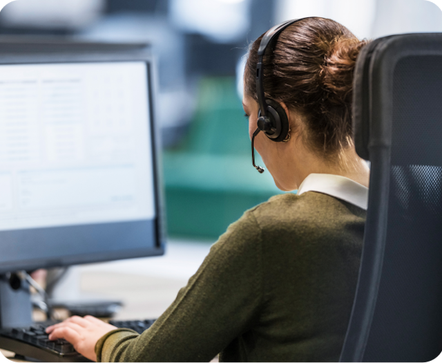 support person with headset and computer